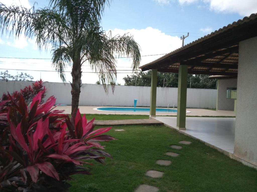 a backyard with a swimming pool and a palm tree at Natal RN Apartamento in Parnamirim