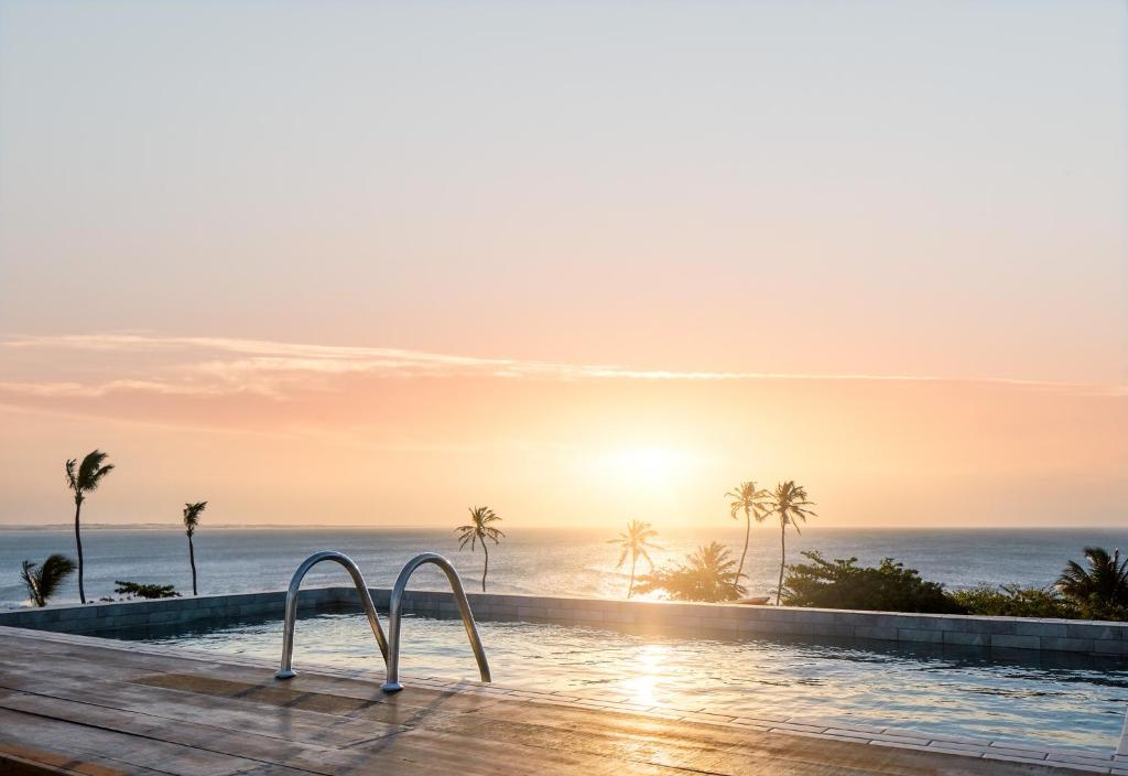 uma piscina de beiral infinito com o oceano ao fundo em Rox Hotel em Jericoacoara