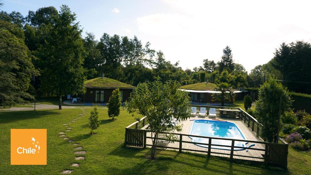 a house with a swimming pool in a yard at Complejo Cabañas Quilamalen in Villarrica