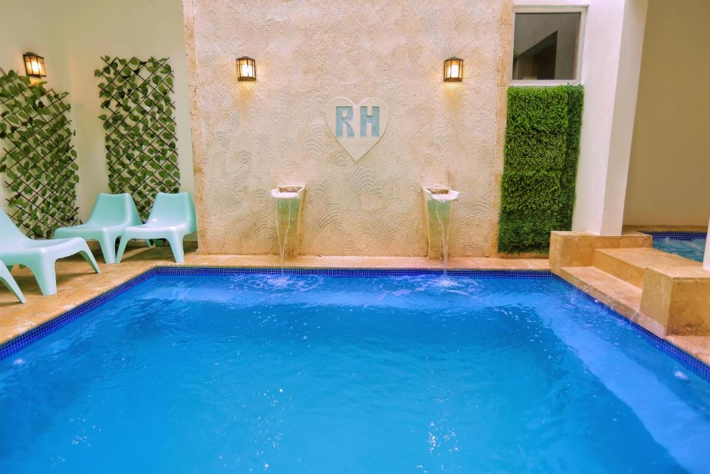 a swimming pool in a hotel with blue water and chairs at RIG Puerto Malecón in Santo Domingo