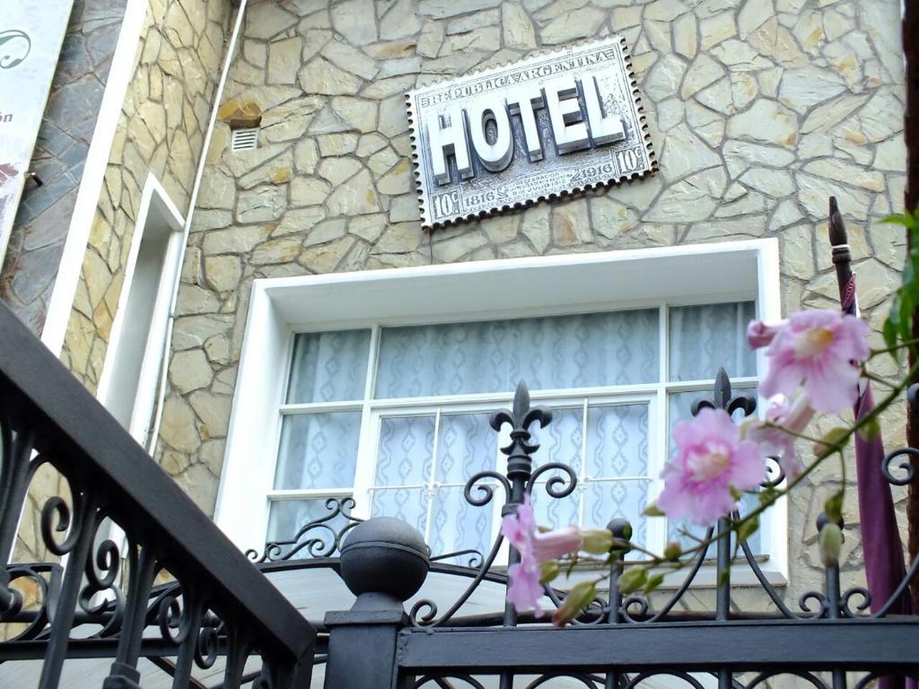 a hotel sign in front of a building with a window at La Casa de Mia Mama in Salta