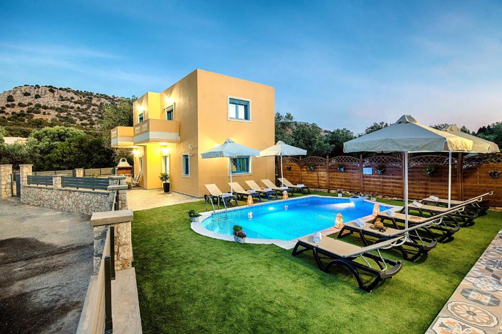 una villa con piscina di fronte a una casa di Lindos Luxury Retro Villas a Líndos