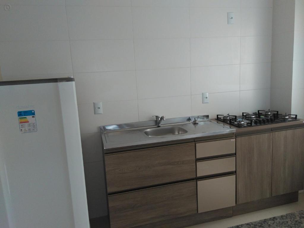 a kitchen with a sink and a stove at Residencial Beira Mar in Cassino