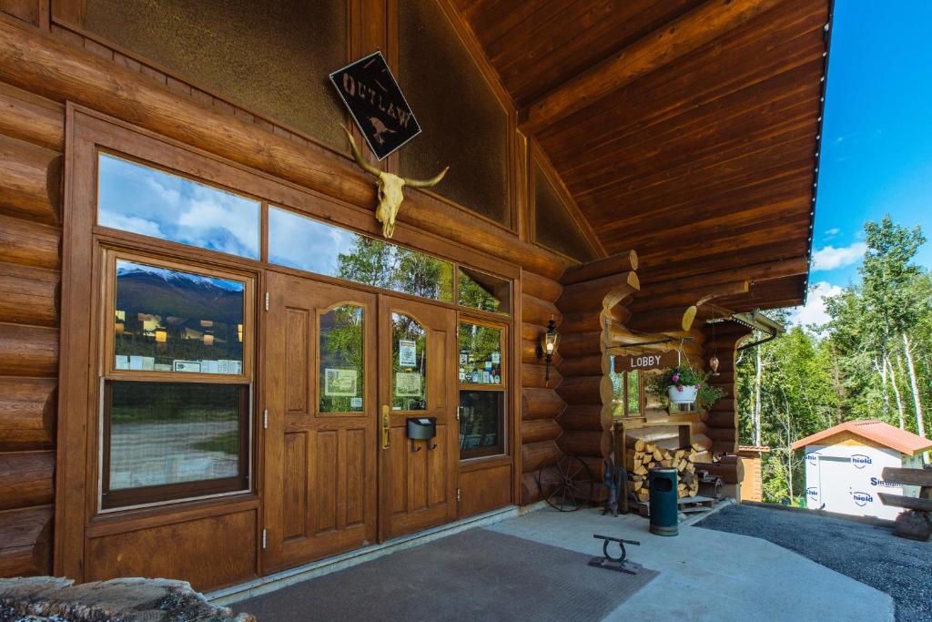 Cabaña con una gran puerta y ventanas de madera en Terracana Ranch Resort, en Tete Jaune Cache