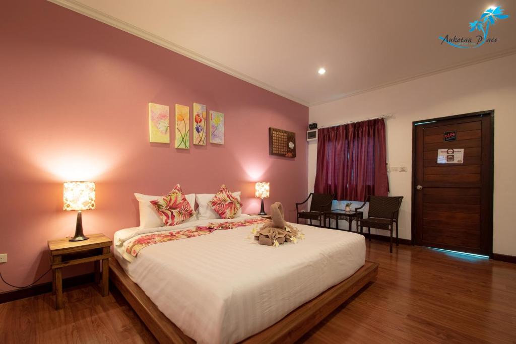 a bedroom with a bed with a cat sitting on it at Aukotan Place in Koh Tao