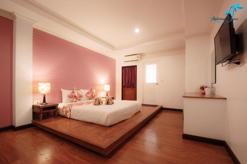 a bedroom with a bed and a television in it at Aukotan Place in Koh Tao