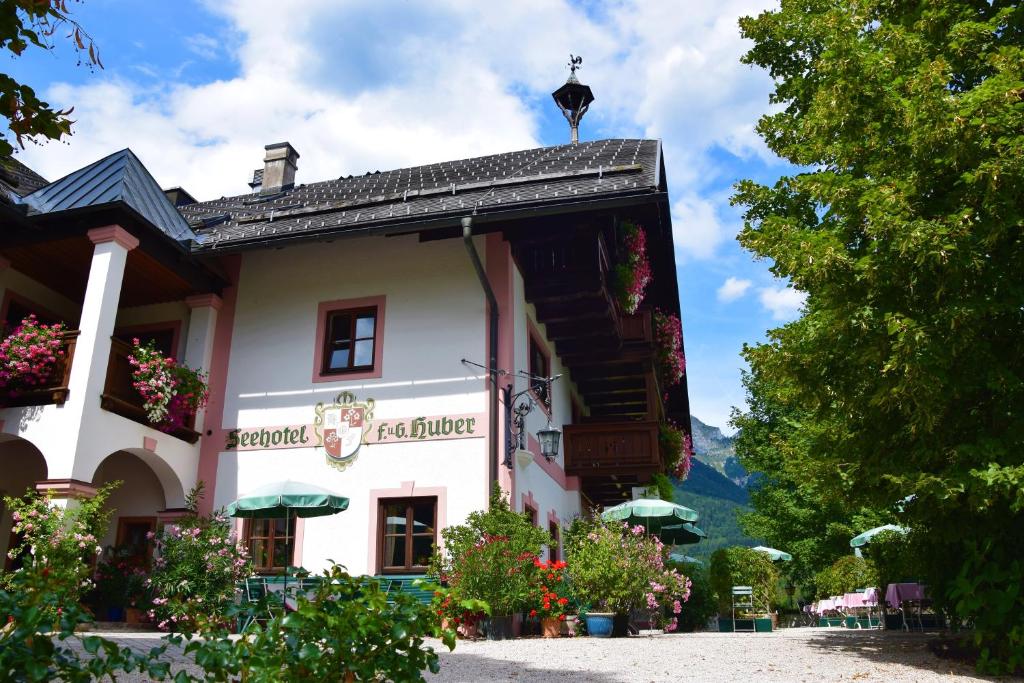 ein großes weißes Gebäude mit Blumen davor in der Unterkunft Seehotel Huber in Sankt Gilgen