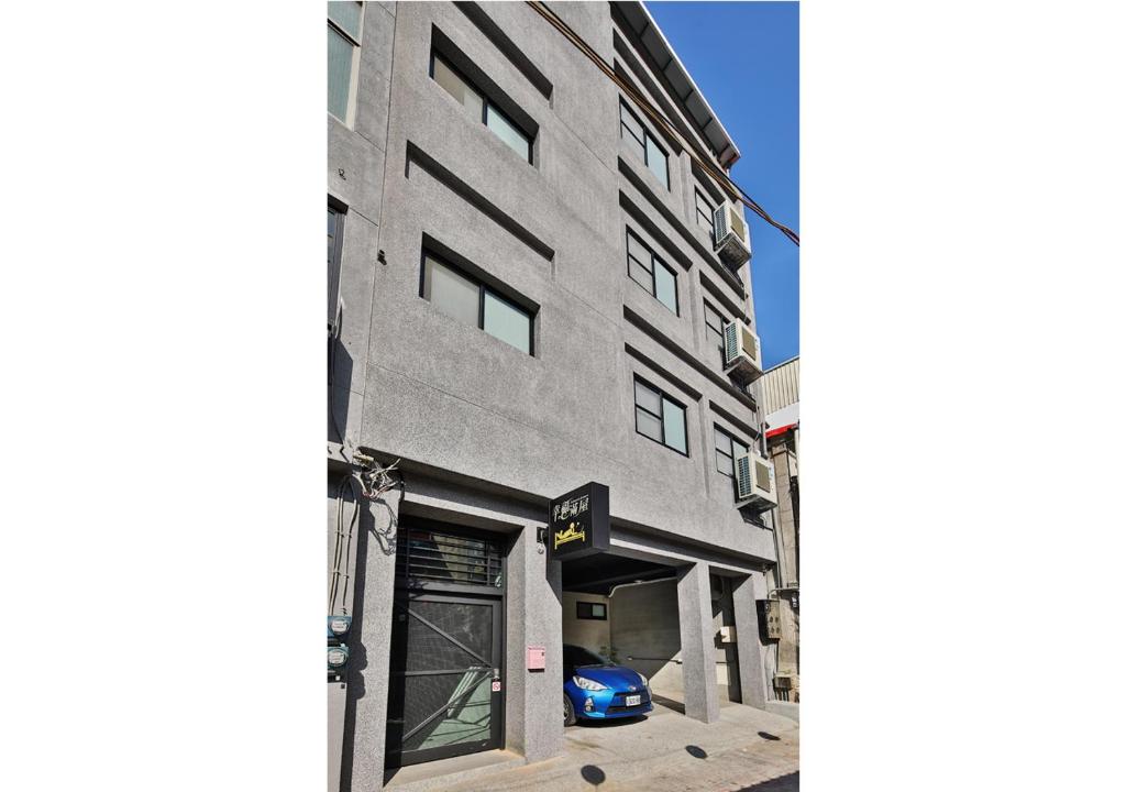 a building with a car parked in front of it at 幸福滿屋 台南6人至40人包棟包層民宿 中西區花園 夜市附近住宿3分鐘 in Tainan