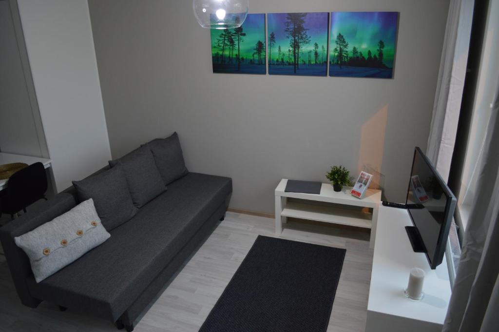 a living room with a couch and a table at Aurora Haven Rovaniemi Modern DT Apartment -Self Check-In & Free Wifi- in Rovaniemi