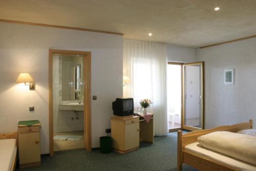a hotel room with a bed and a television at Spessarter Hof in Hobbach