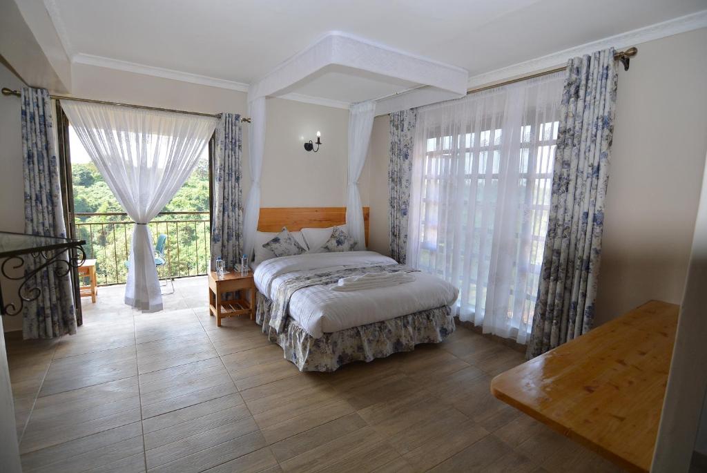 a bedroom with a bed and a large window at Bubbles Restaurant Thika in Thika