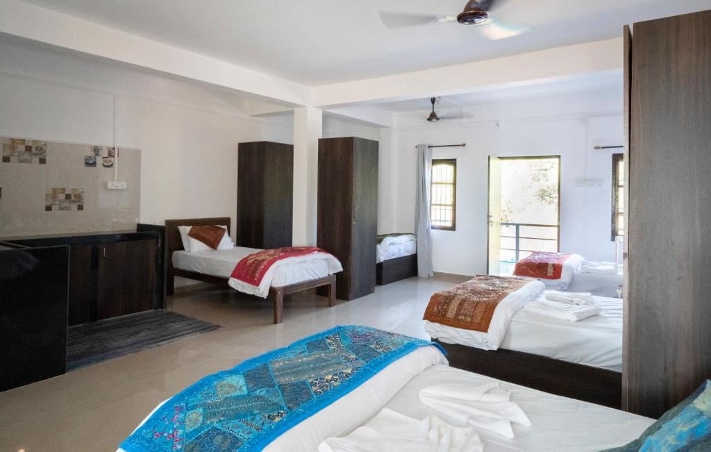a hotel room with two beds and a tv at de LAVENDER ac HOSTEL in Agonda