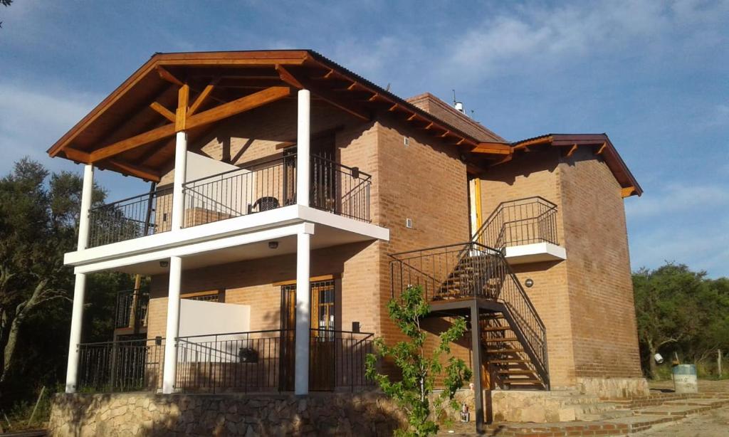a large brick building with a balcony and stairs at Mirador del Valle in Mina Clavero