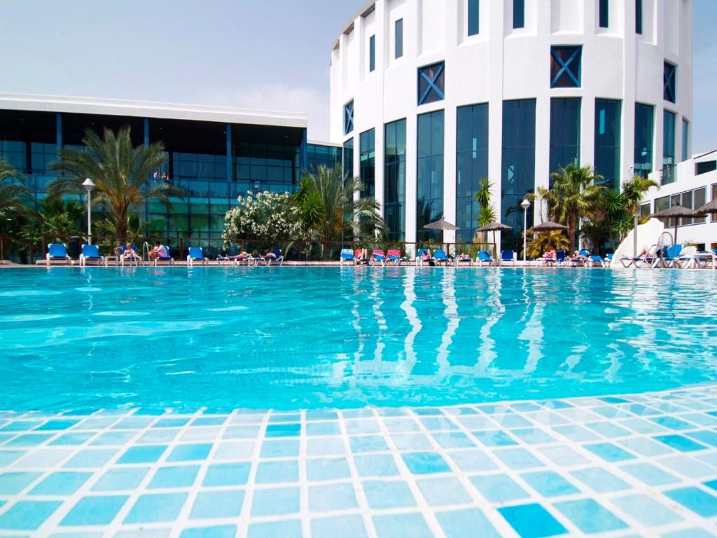 a swimming pool in front of a hotel at Sandos Papagayo in Playa Blanca