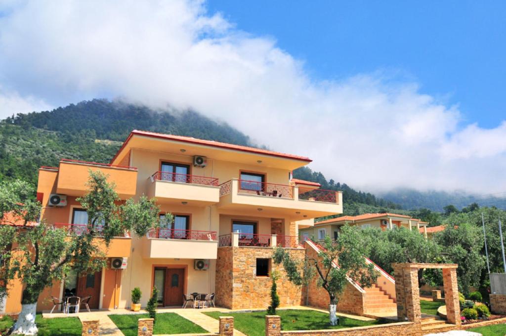 a building with a mountain in the background at CORALI STUDIOS in Chrysi Ammoudia