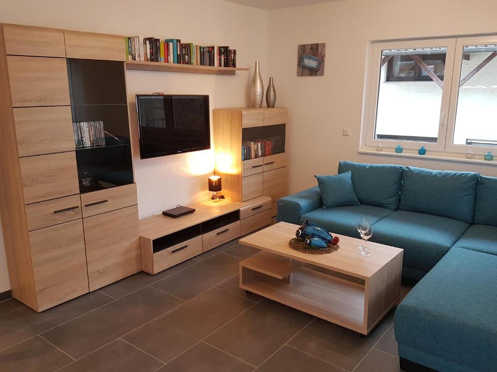 a living room with a blue couch and a tv at Ferienwohnung Moritz in Sankt Aldegund