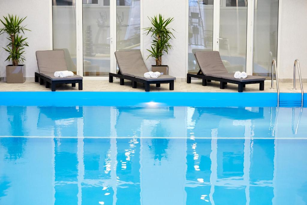 duas fotos de uma piscina com duas cadeiras e a água em Cruise Hotel em Tbilisi