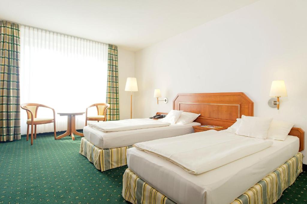 Postel nebo postele na pokoji v ubytování Maifeld Sport- und Tagungshotel