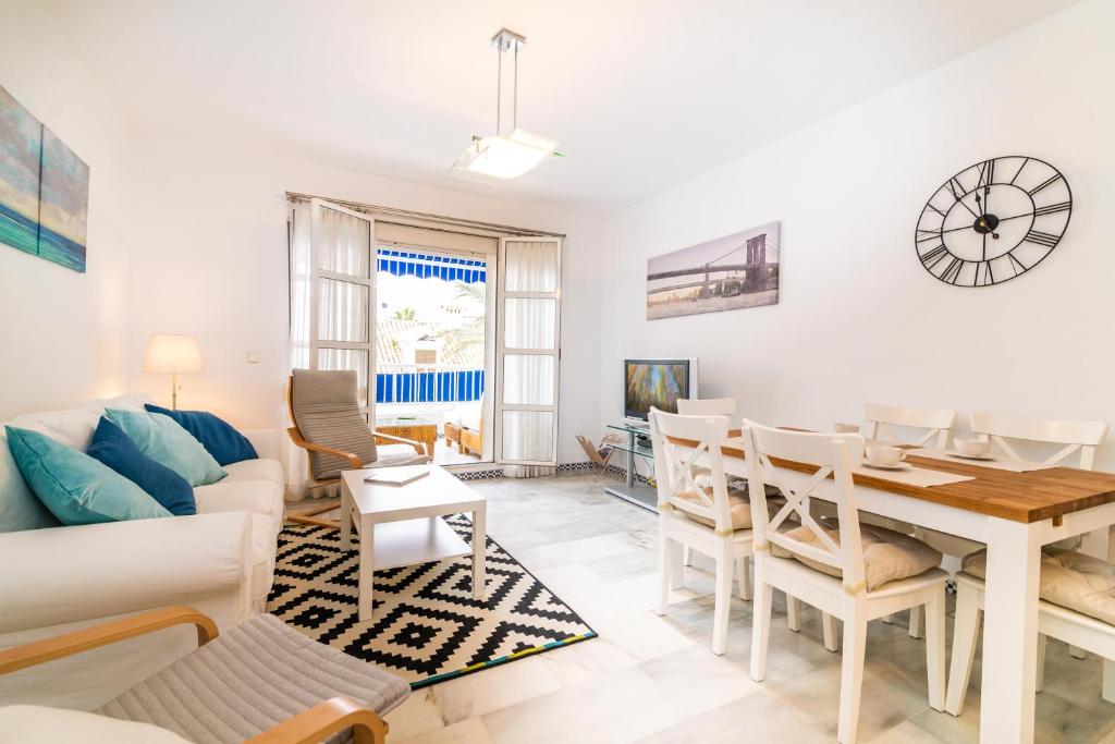 フエンヒロラにあるWell-located 3BDR Apartment in Fuengirolaのリビングルーム(テーブル、椅子、ソファ付)