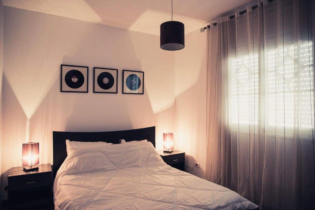 a bedroom with a bed and two night stands with lamps at Home sweet home in El Aouina