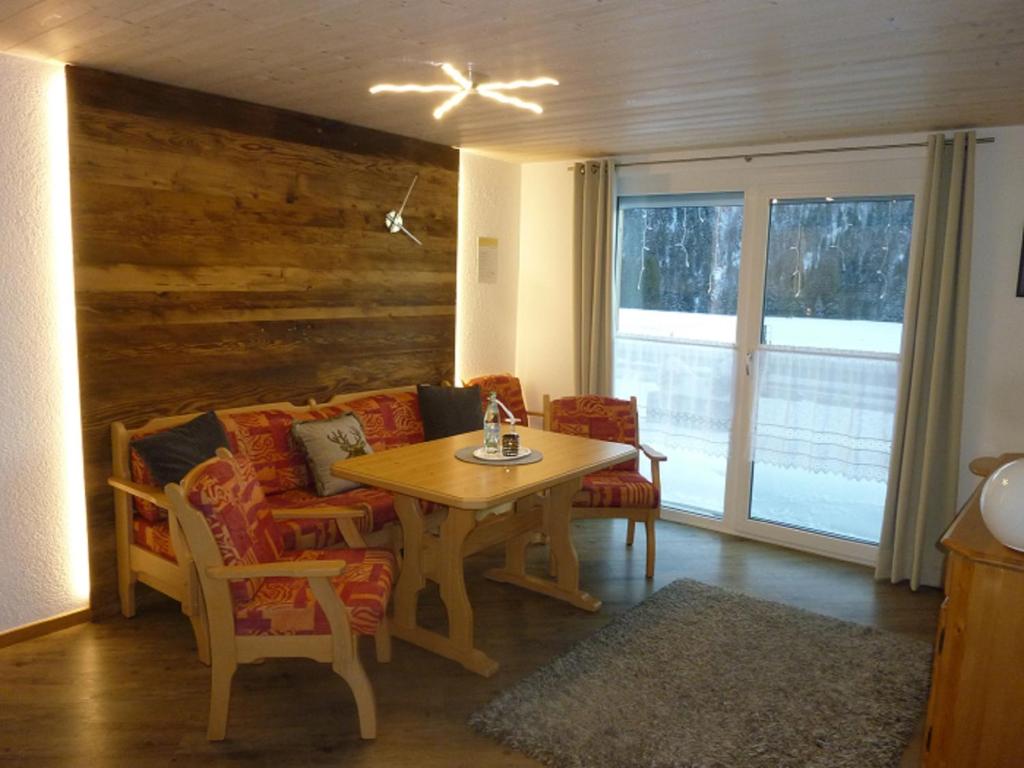 sala de estar con mesa de madera y sillas en Ferienhof "Alpe Berg", en Balderschwang