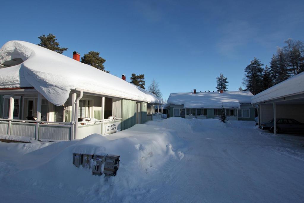 a yard covered in snow next to a house at Kotareitti Apartments in Rovaniemi