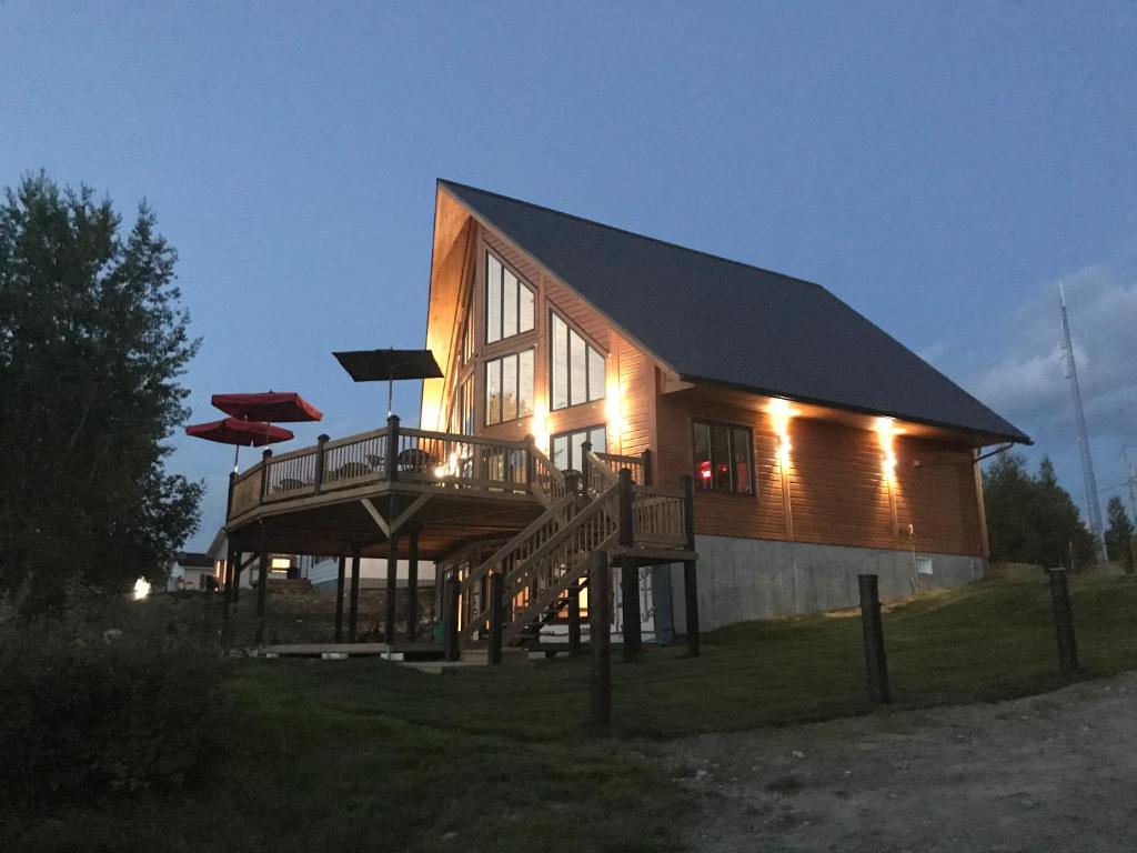 ein großes Holzhaus mit einer Veranda und einer Terrasse in der Unterkunft Marina Chibougamau in Chibougamau