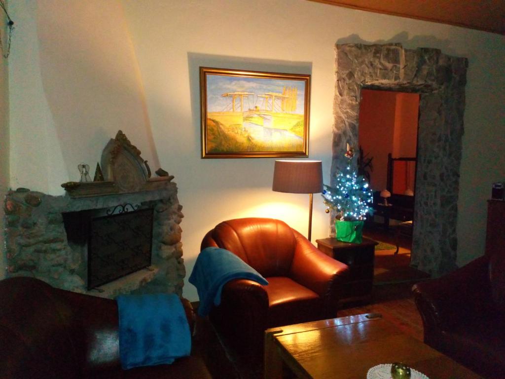 a living room with a chair and a fireplace at Gospodarstwo u Krakusa in Doboszowice