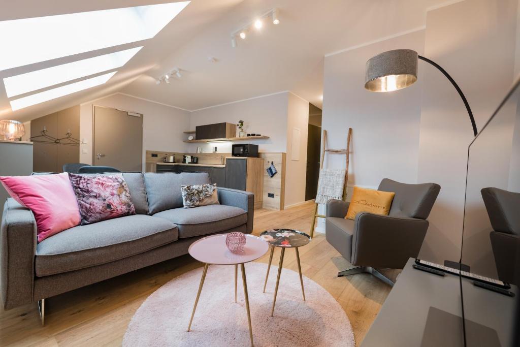 a living room with a couch and a table at Suites MITTE - Aparthotel in Eisenach