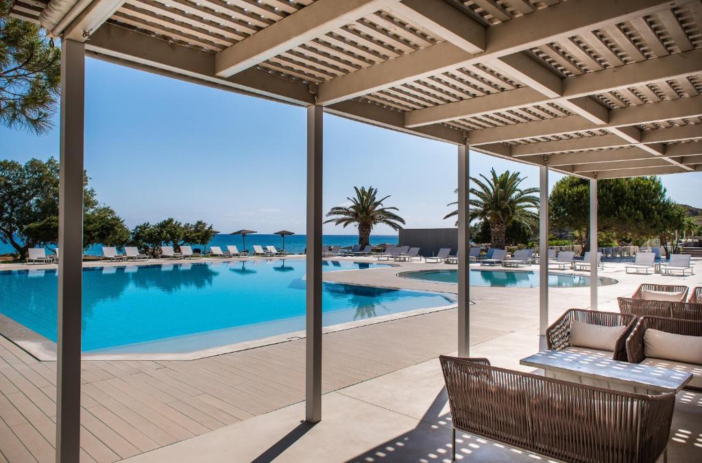 a view of the pool from the patio of a resort at The Bay Hotel & Suites in Vasilikos