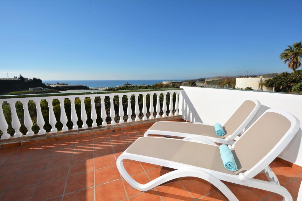 a white chair on a balcony with the ocean at Pura Vida El Morche in Torrox Costa