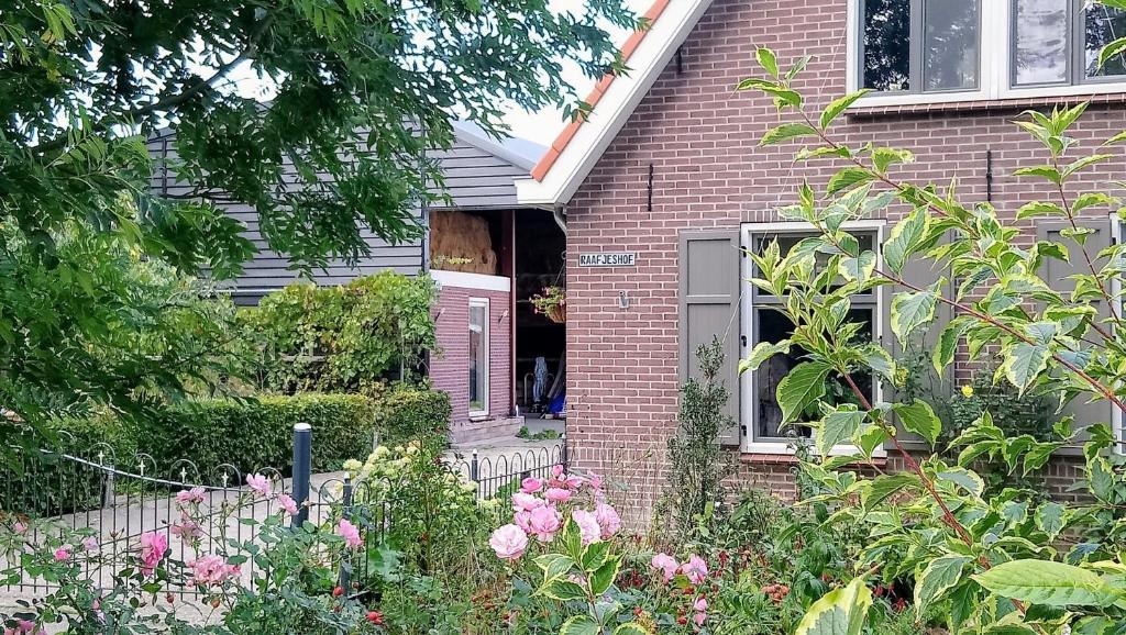 una puerta abierta de una casa de ladrillo con flores en Raafjeshof, en Culemborg