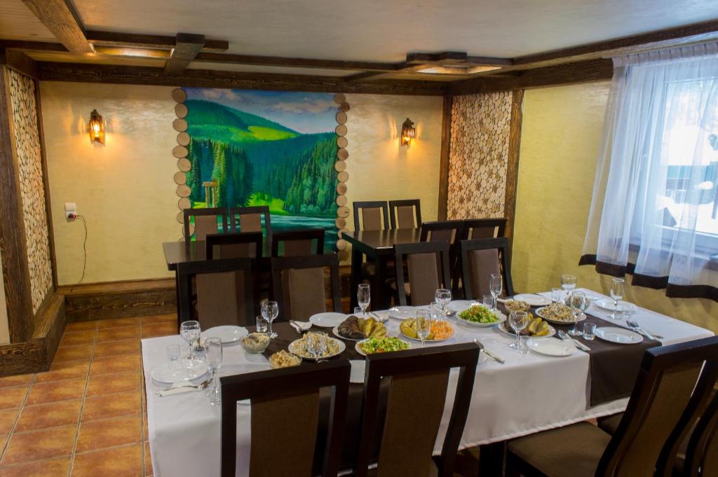 a dining room with a table with plates of food at Synevyrskyj Chardash in Synevyr