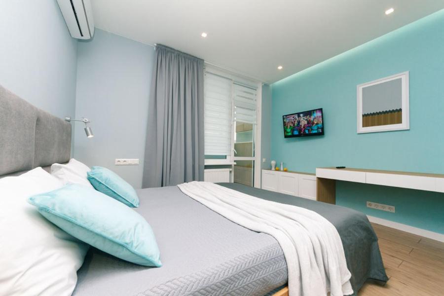ein Schlafzimmer mit einem großen Bett mit blauen Wänden in der Unterkunft Happy apartment, warmth, comfort, turquoise in Kiew