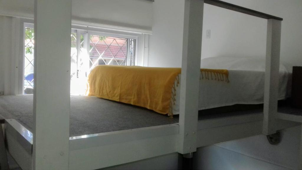 1 dormitorio con 1 cama con manta amarilla en Depto en PH Planta baja al Frente en Buenos Aires