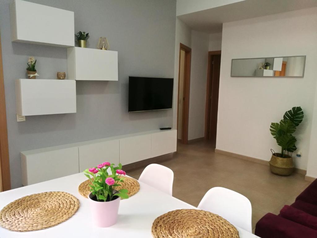 ein Wohnzimmer mit einem Tisch und Stühlen sowie einem TV in der Unterkunft Rincón del mercado in Las Palmas de Gran Canaria
