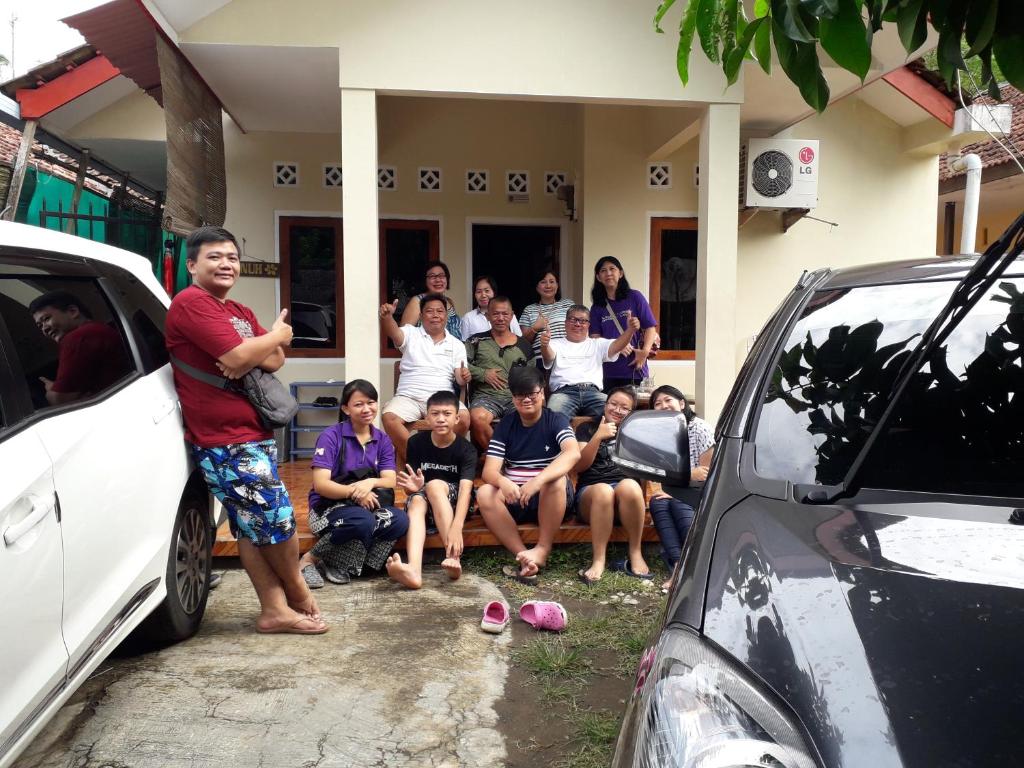 een groep mensen die voor een huis zitten bij Fajar Home Stay Batukaras in Batukaras