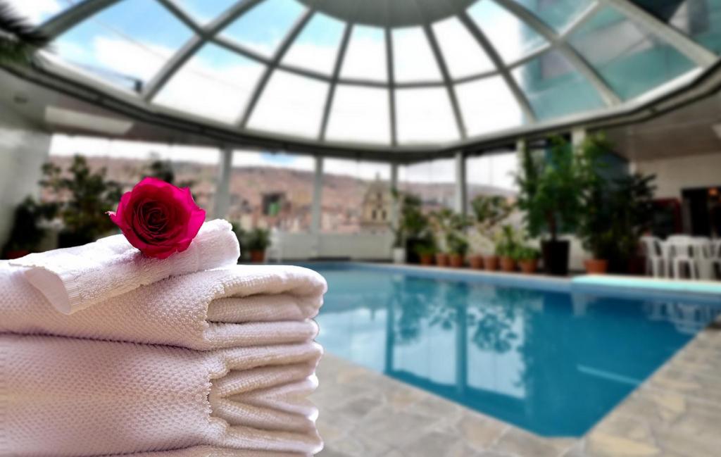 a towel with a rose on it next to a swimming pool at Hotel Presidente in La Paz