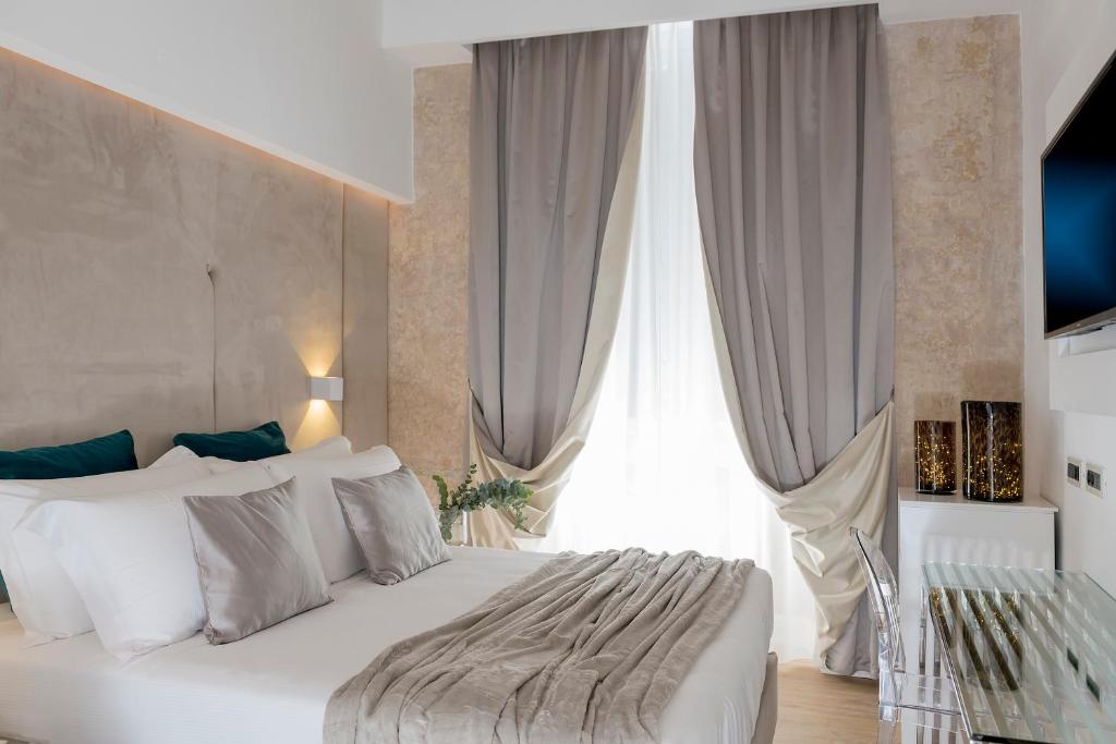 a bedroom with a white bed and a large window at Navona Style in Rome