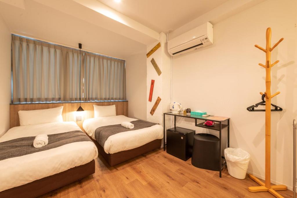 大阪市にあるYeah Room Nambaのベッド2台と壁のクロスが備わるホテルルームです。