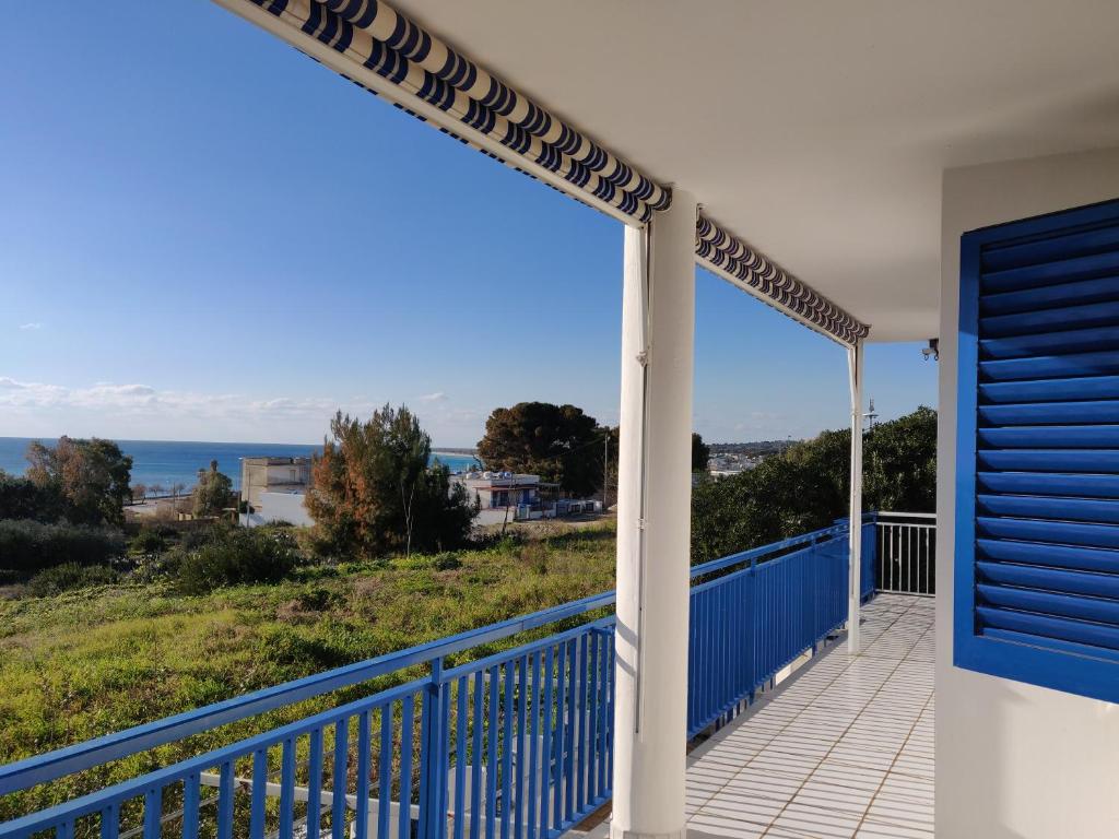 balcón con puerta azul y vistas al océano en Villetta Blu Mare en Torre Vado
