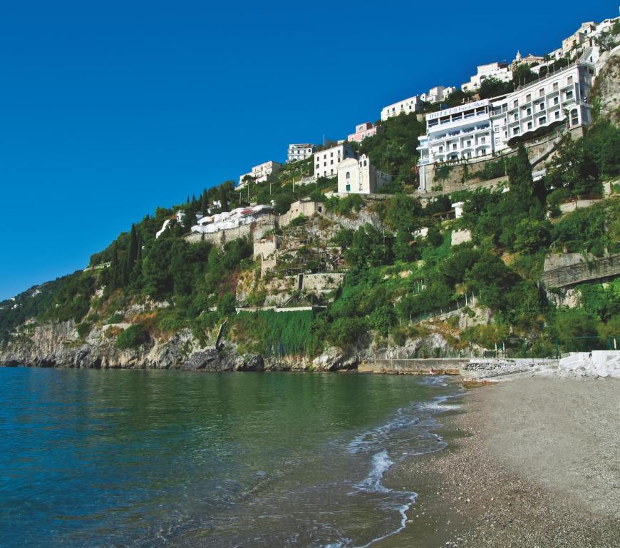 a view of a mountain with houses on a beach at Hotel Voce del Mare in Vietri sul Mare