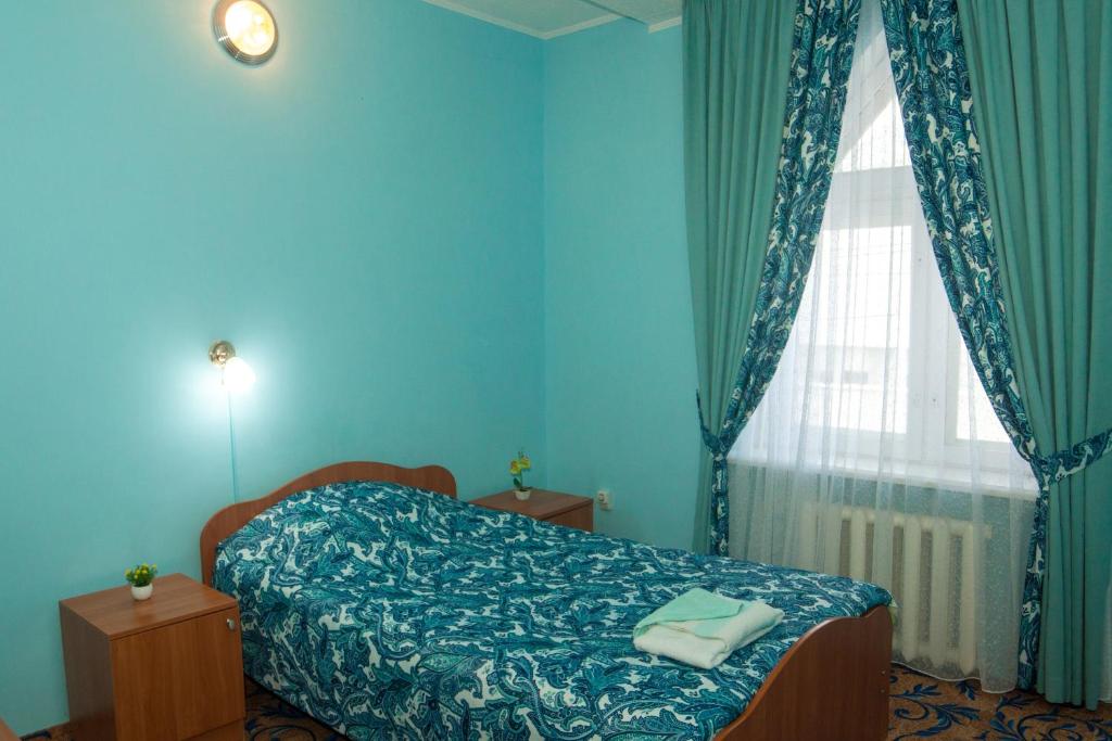 SalavatにあるSalavat Motelの青いベッドルーム(ベッド1台、窓付)