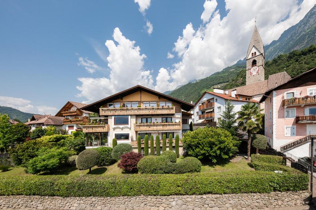 a building with a church in the mountains at Pension Monika in Lagundo