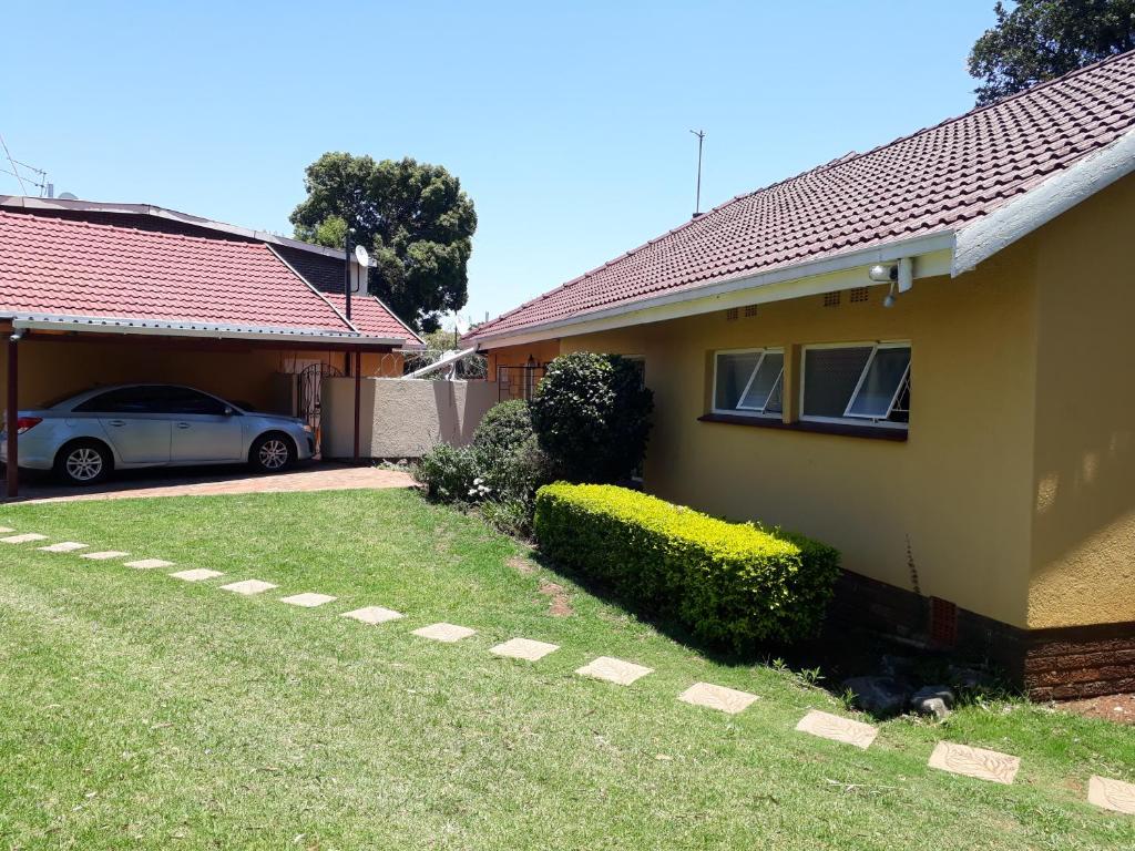 a house with a car parked in the driveway at Peace & Lovely Bed and Breakfast in Johannesburg