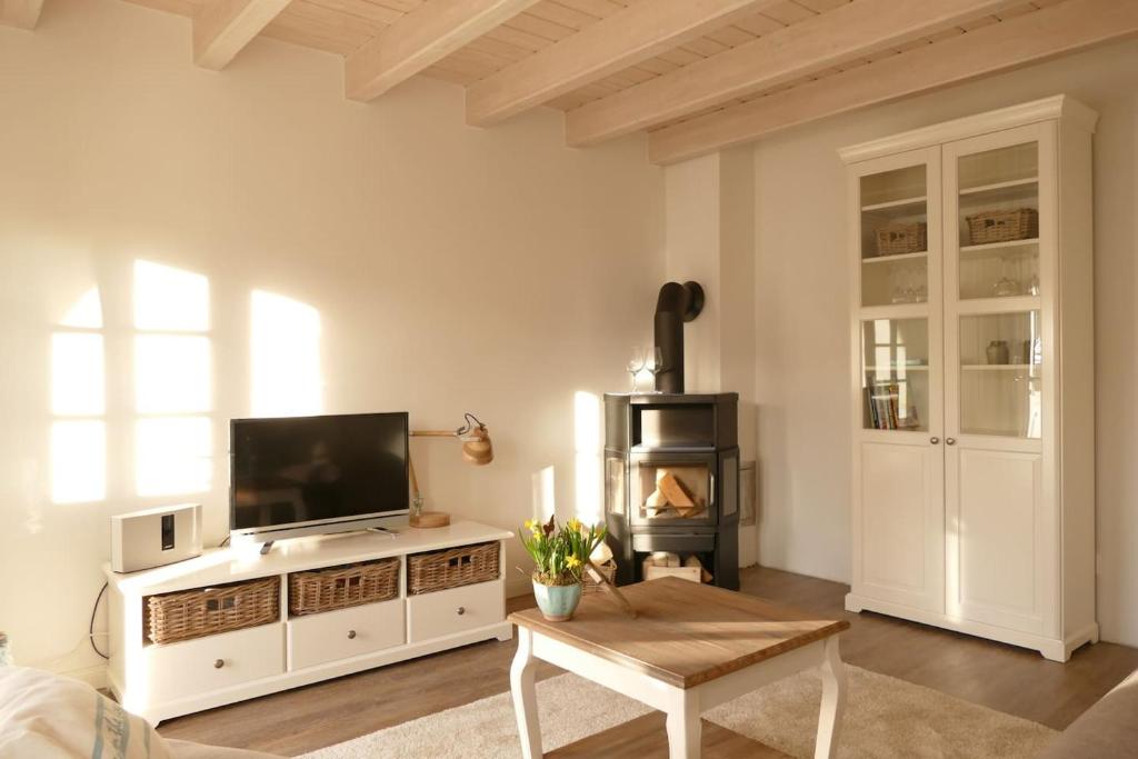 a living room with a television and a table at Lieblingsplatz in Wrixum