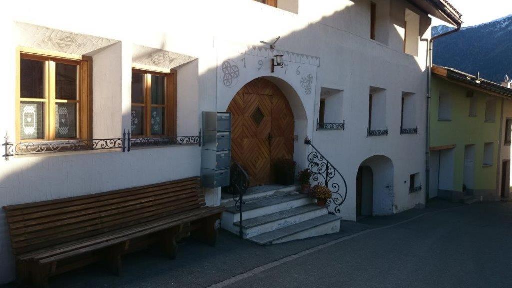 a building with a wooden door and a wooden bench at Ninetta in Valchava