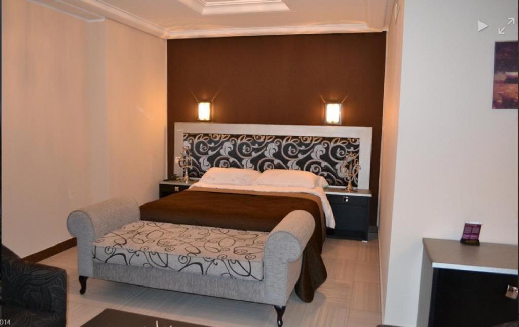 a bedroom with a bed and a couch in it at Jardy Hotel in Bab Ezzouar