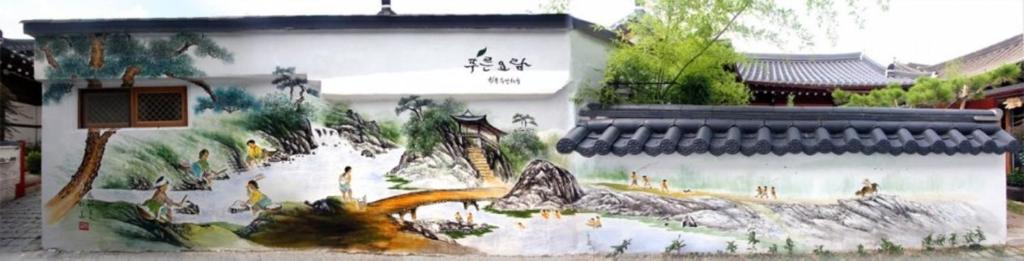 um edifício com uma pintura ao lado dele em The Blue Cradle em Jeonju