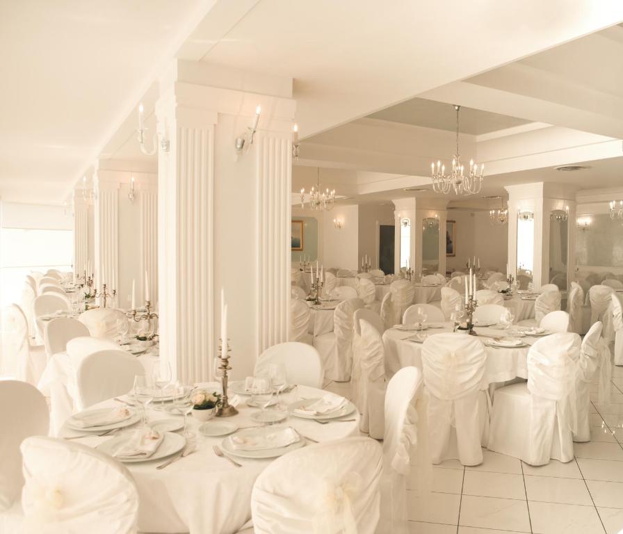 a dining room with white tables and white chairs at Hotel Voce del Mare in Vietri sul Mare